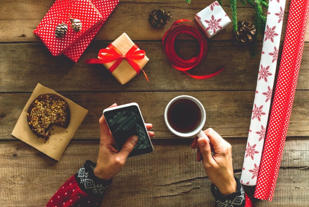 Female holding smartphone and cup of tea