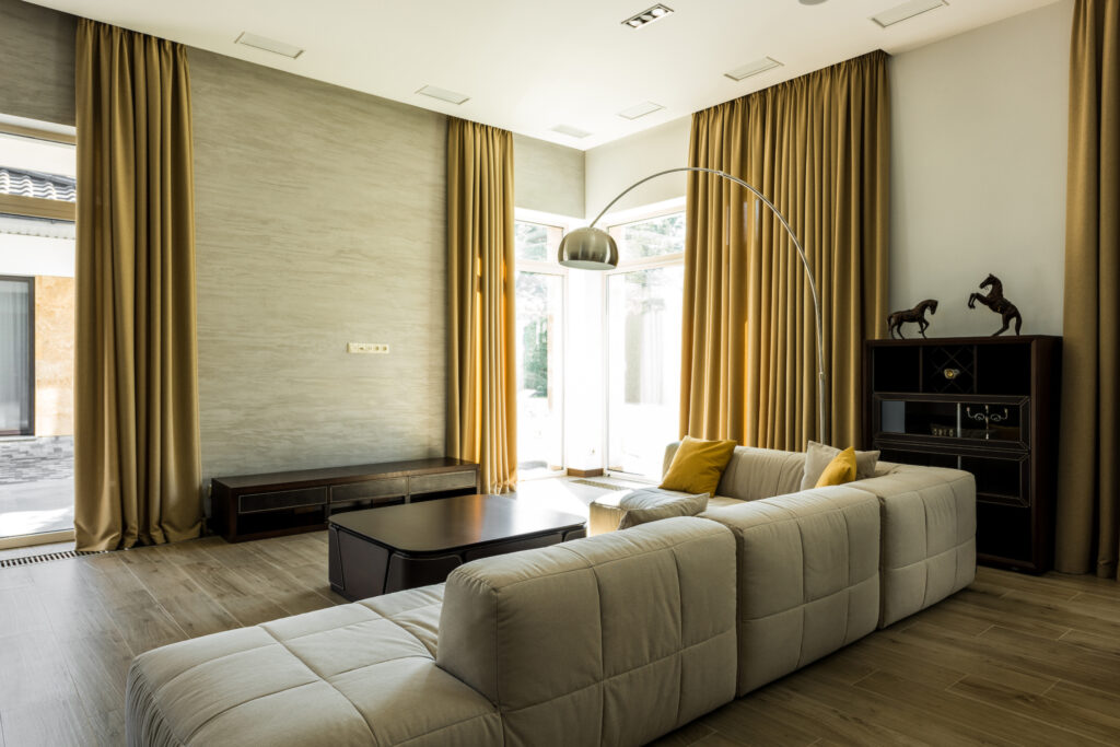 interior of empty modern living room with sofa and big windows with curtains